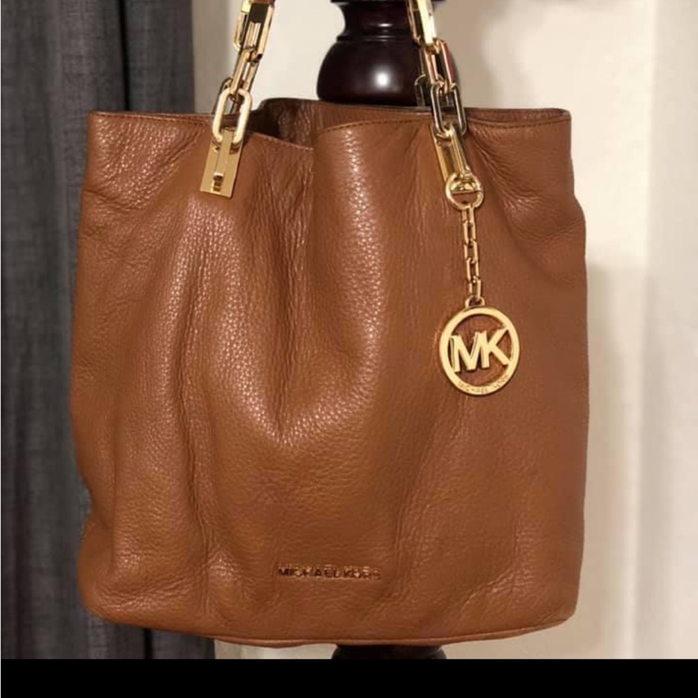 Used Micheal Kors tan leather purse with gold tone hardware. Includes dust bag.
